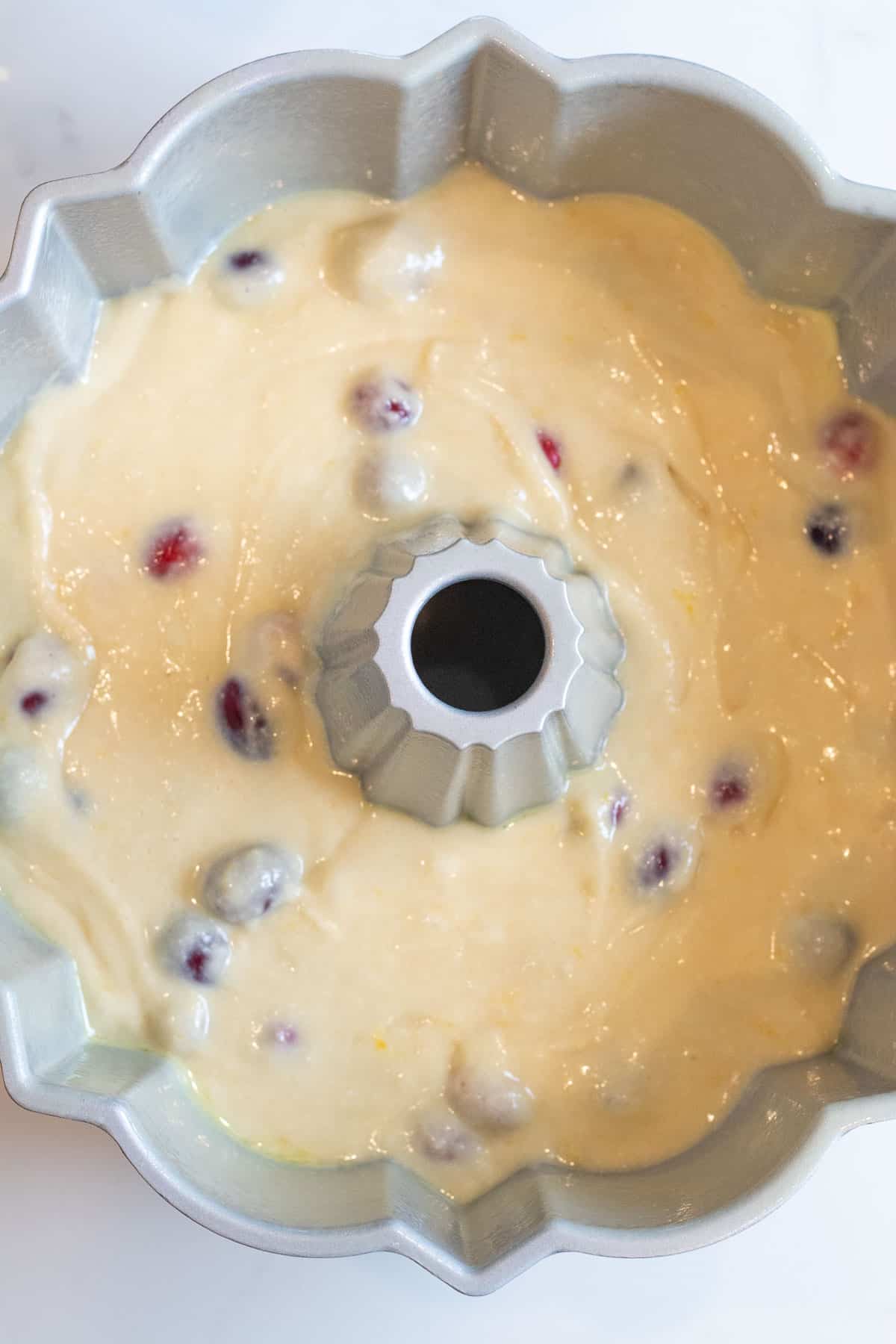 cranberry orange cake batter in a bundt pan