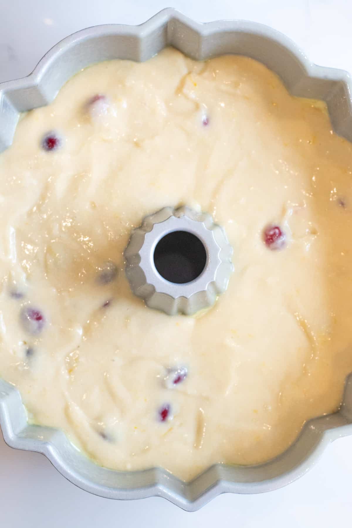 cranberry orange cake batter in a bundt cake pan