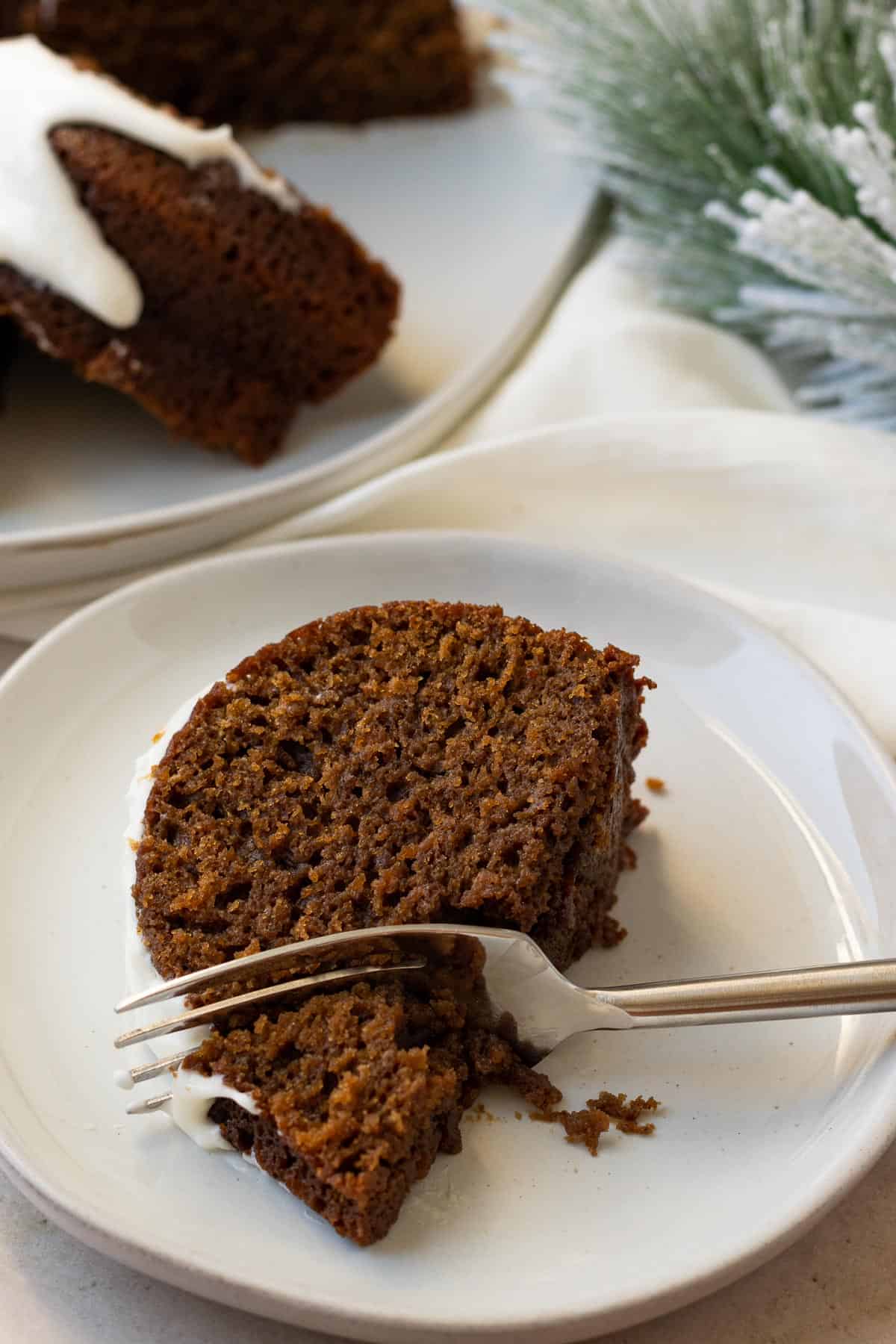 slice of gingerbread cake on a white plate with a fork 