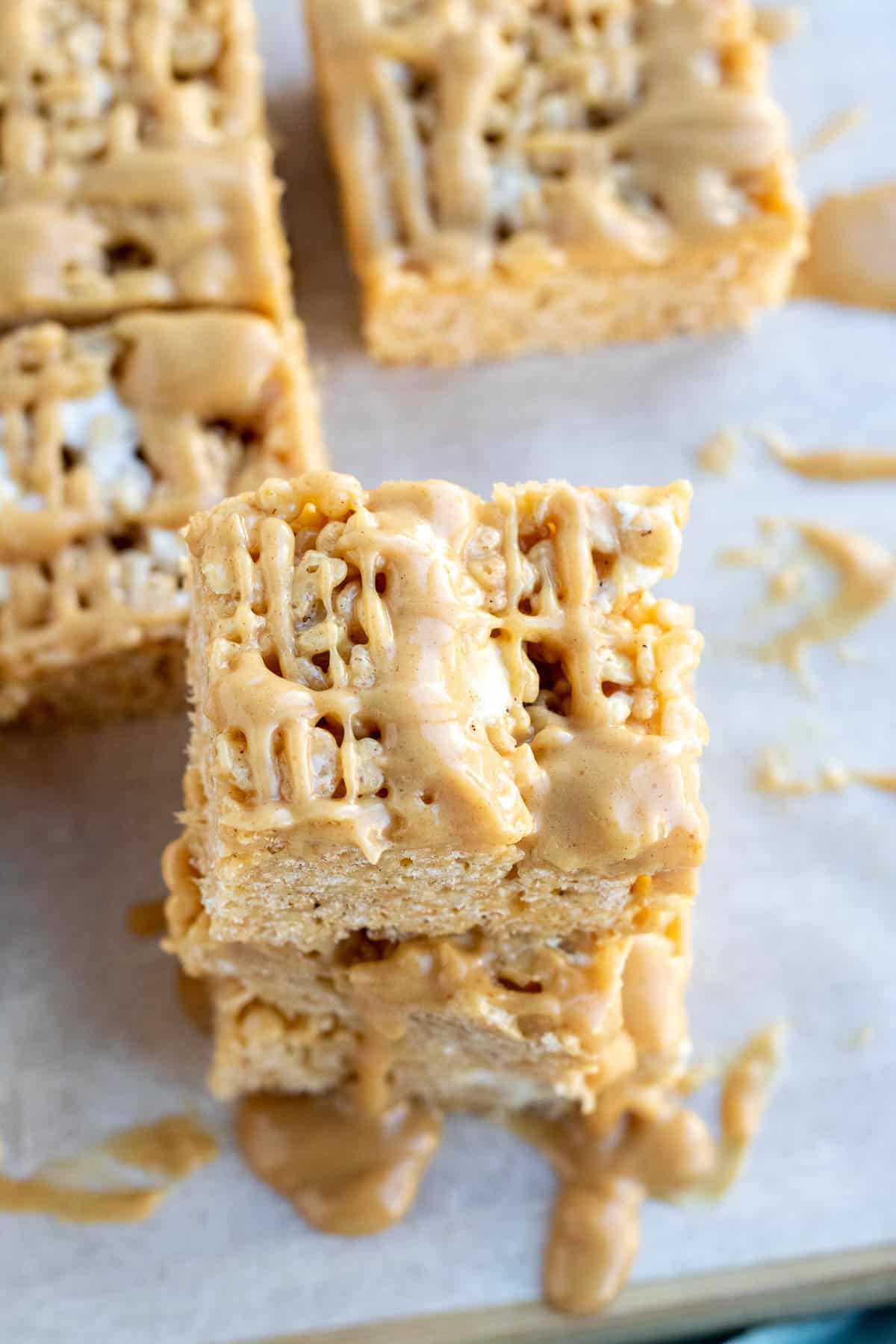 close up of a peanut butter rice krispie bar with a peanut butter drizzle