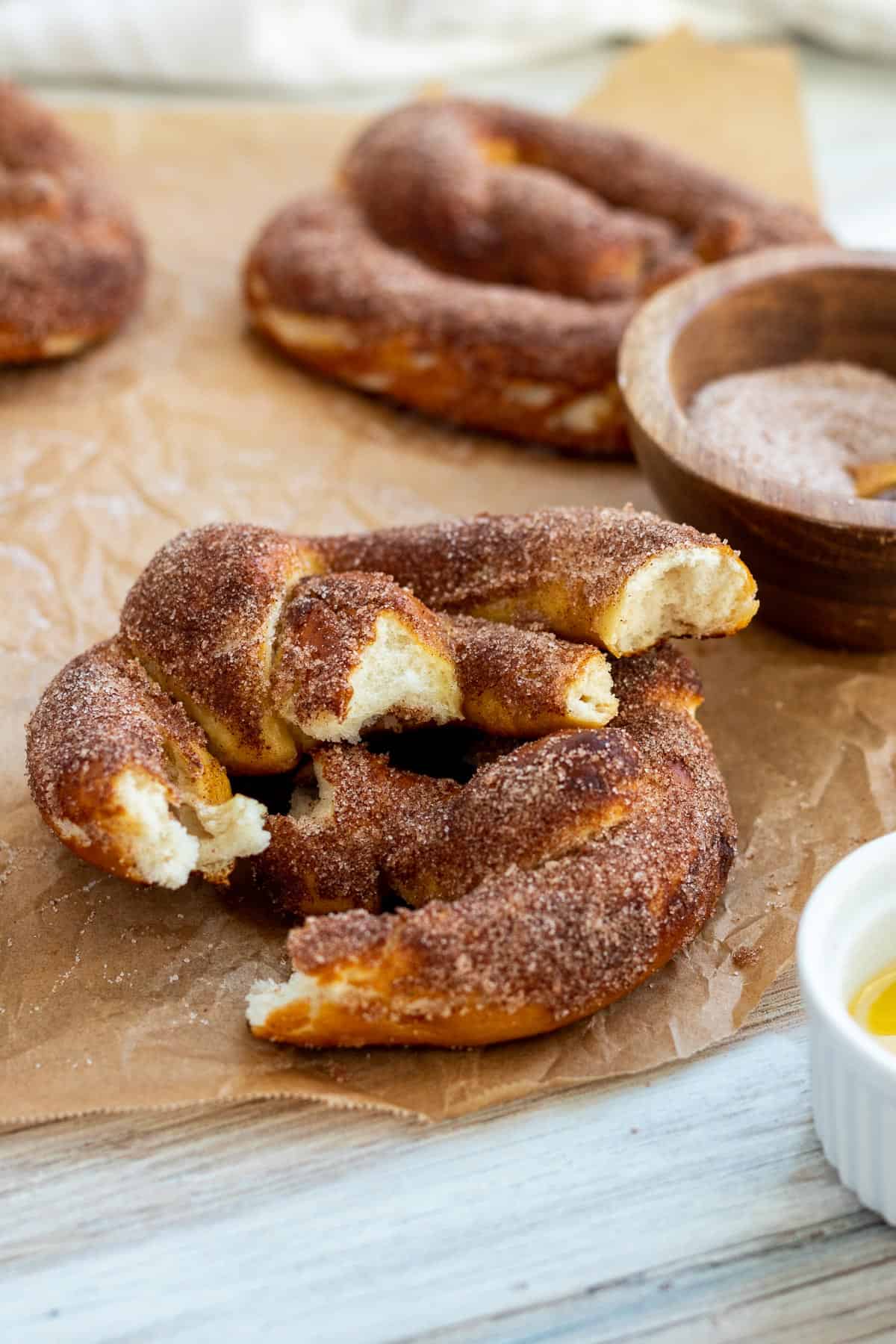 cinnamon pretzel split into two sitting on parchment paper