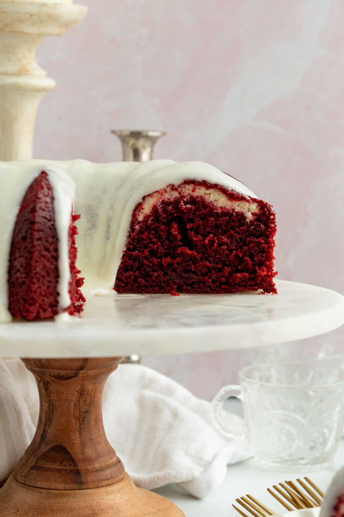 red velvet bundt cake on a cake stand , sliced to see the inside of the cake