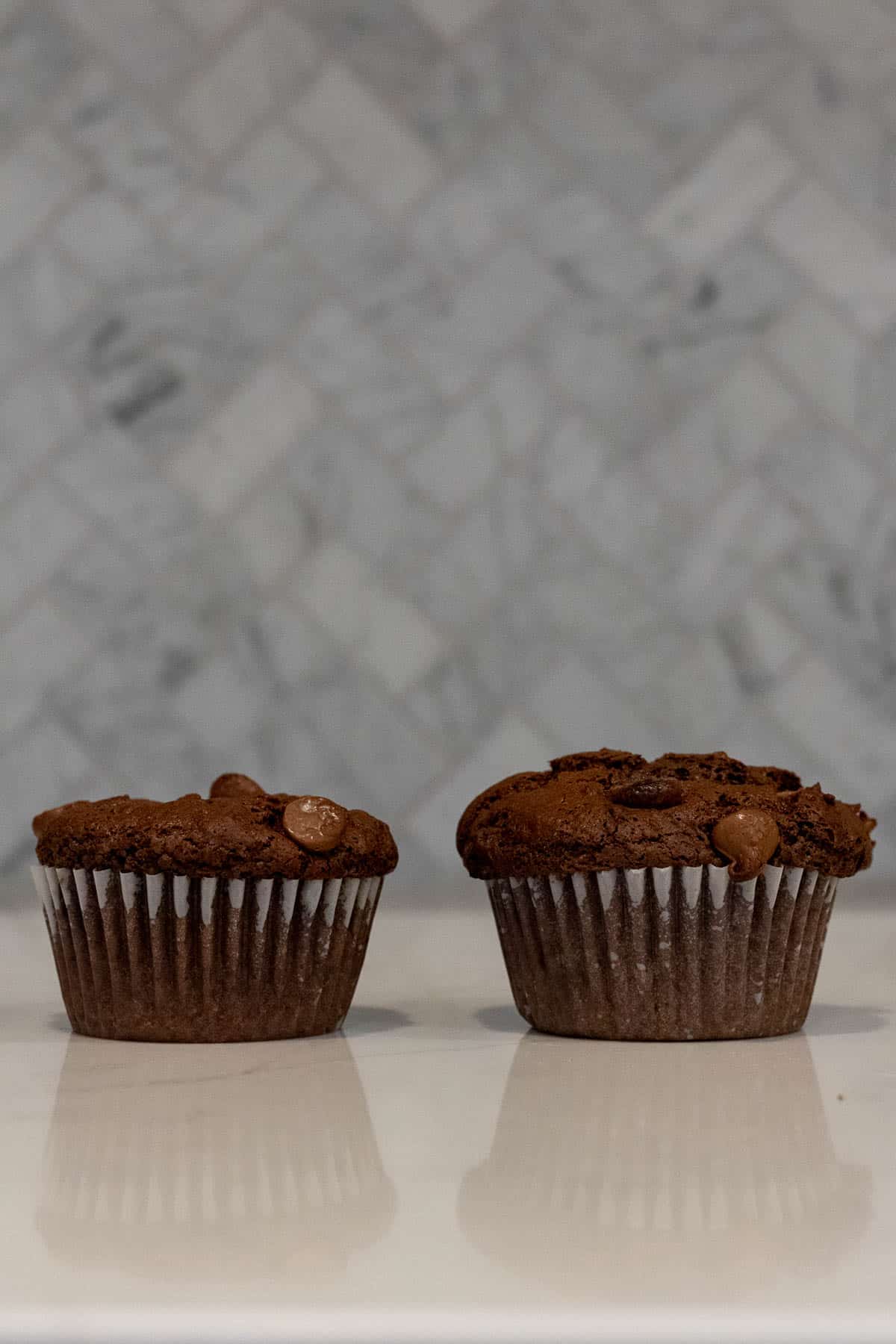 comparison of 2 chocolate muffins with one muffin top more domed than the other