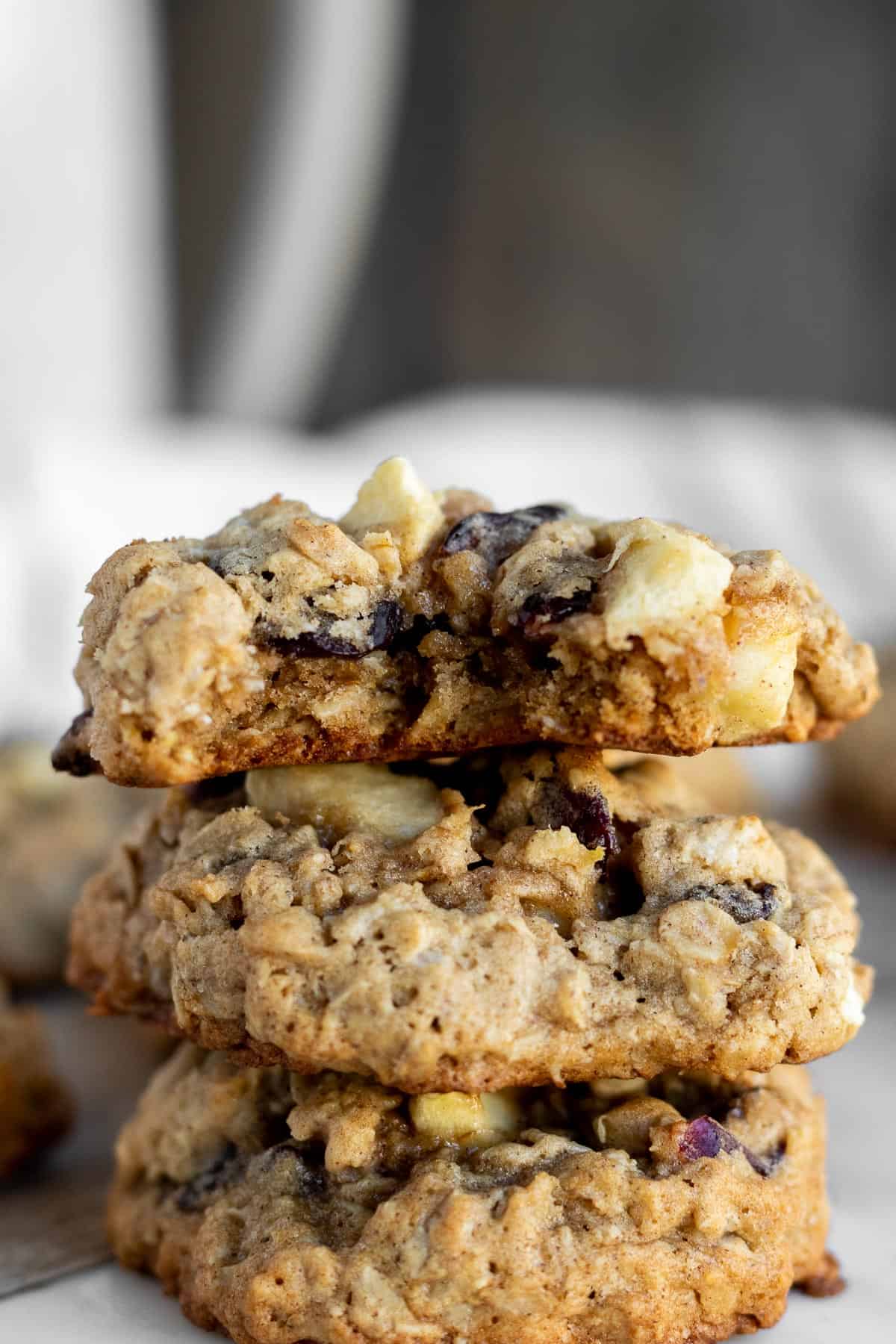 apple oatmeal cookies stacked on top of each other with a bite out of the top one