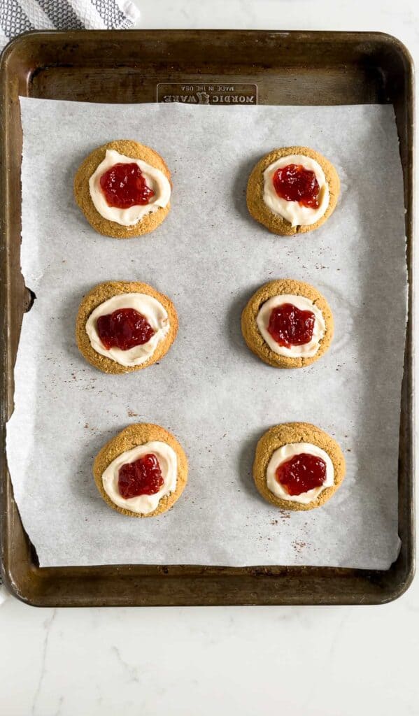 strawberry cheesecake cookies on a cookie sheet with parchment paper