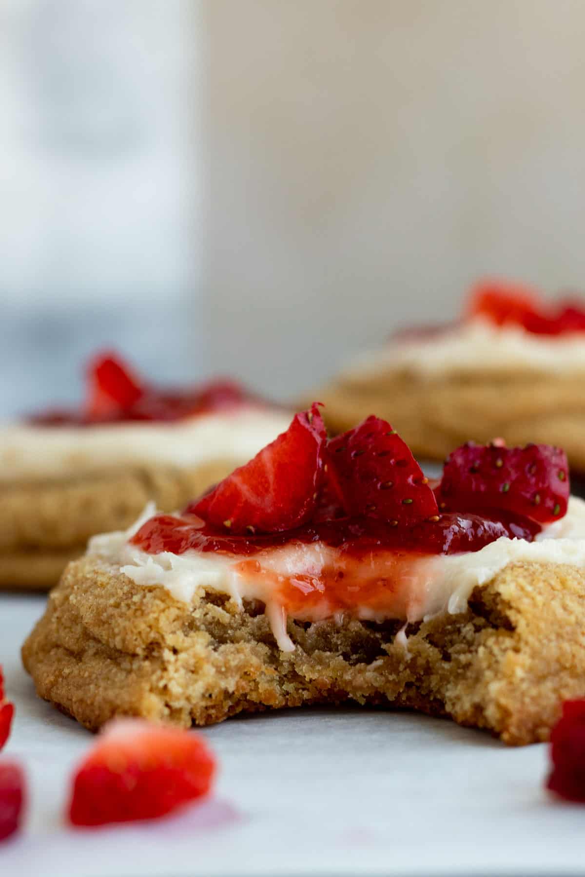 close up of a strawberry cheesecake cookie with a bite out of it