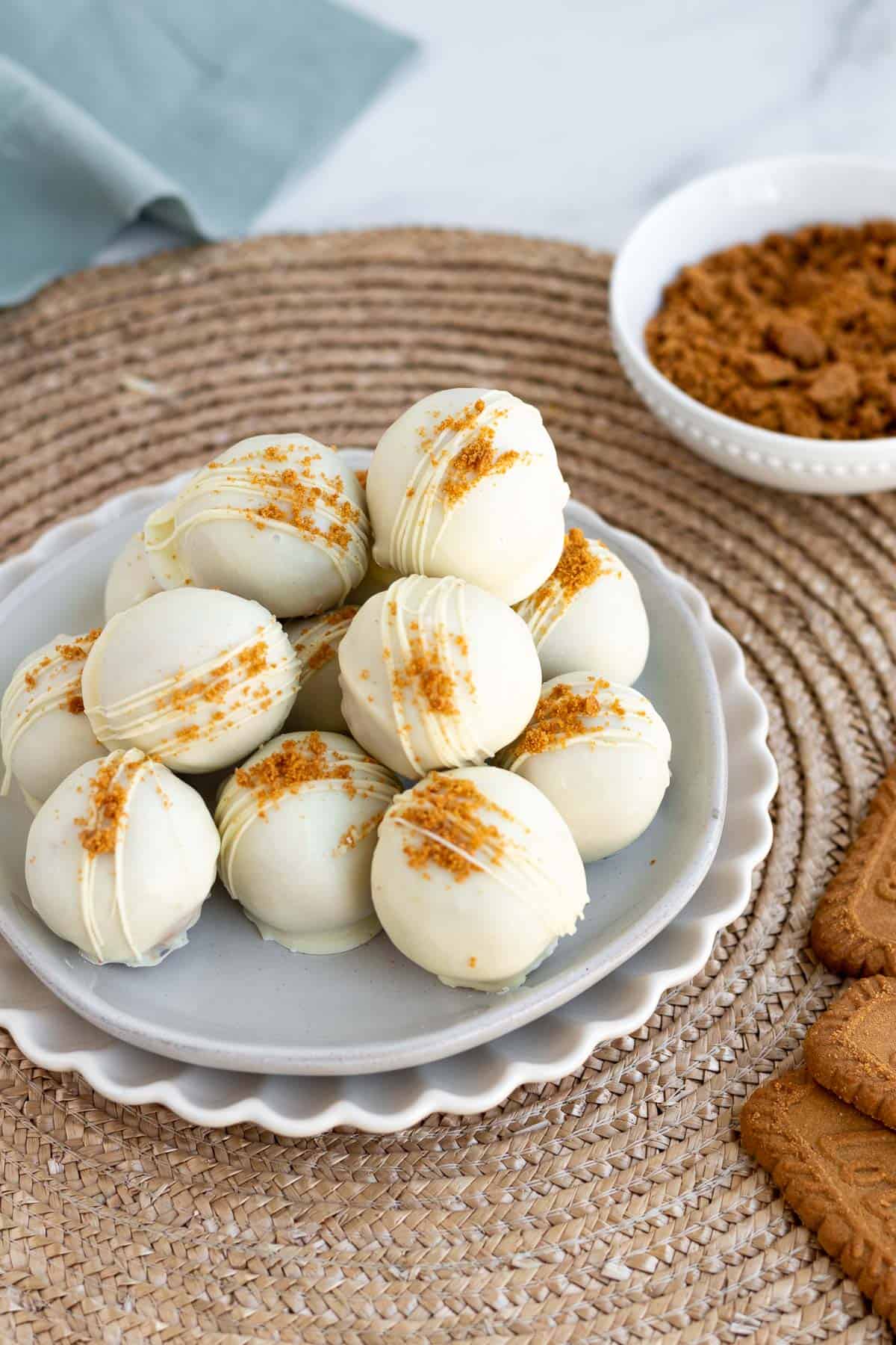 a pile of white chocolate covered biscoff truffles on a gray plate