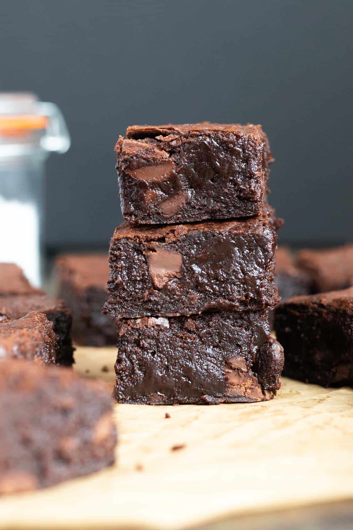 a stack of three dark chocolate brownies against a dark background