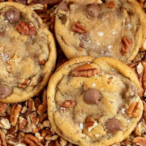 chocolate chip pecan cookies laying on top of chopped pecans