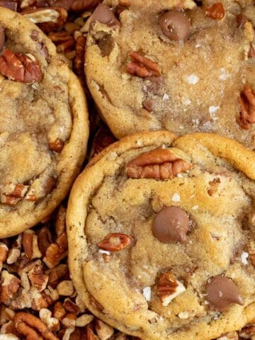 chocolate chip pecan cookies laying on top of chopped pecans